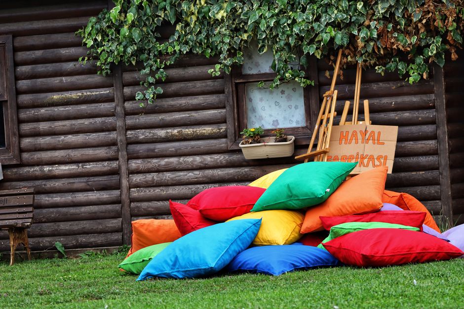 Beschermde tuinkussens onder houten terrasbank.